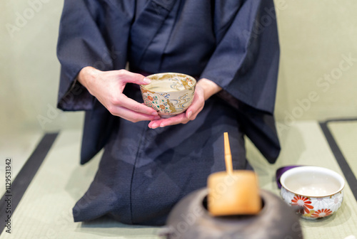 People preparing for tea ceremony at traditional Japanese house (ryokan) in Kyoto, Japan.