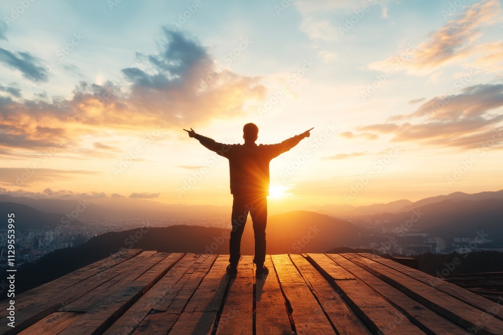 Fototapeta premium Individual enjoying a sunset atop a mountain with arms outstretched, embracing nature's beauty