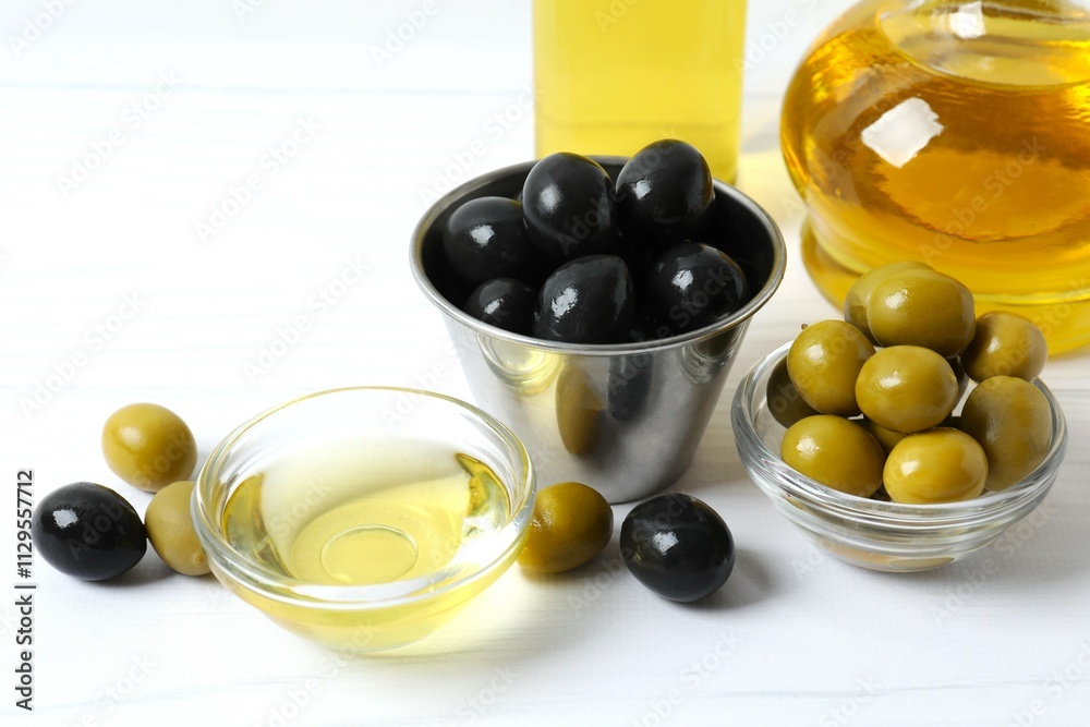 Bowl of fresh olive oil and olives with leaves on the table Bowl of fresh olive oil and olives with leaves on the table