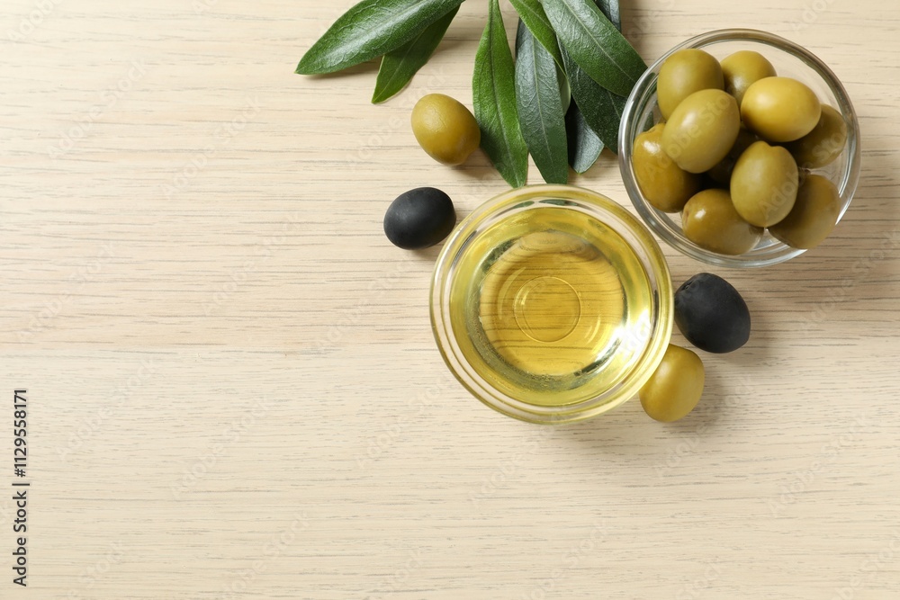 Bowl of fresh olive oil and olives with leaves on the table Bowl of fresh olive oil and olives with leaves on the table