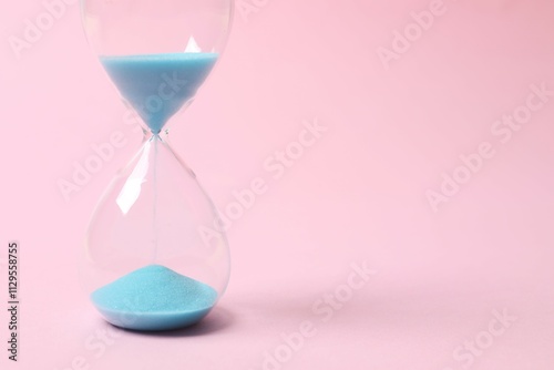 Modern hourglass on color background. Hourglass time concept for business deadline, urgency and outcome of time photo