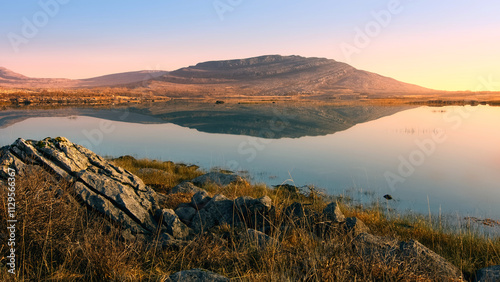Beautiful sunrise landscape scenery of Mullaghmore mountain reflected in Lake at Burren National Park in county Clare, Ireland, nature background	