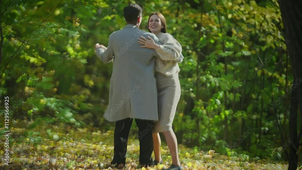 A couple dances joyfully together beneath vibrant autumn leaves, celebrating their love and natures stunning beauty A couple dances joyfully together beneath vibrant autumn leaves, celebrating their love and natures stunning beauty