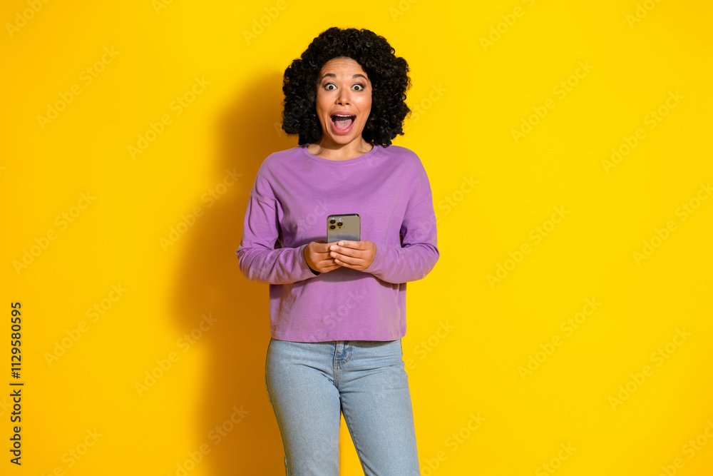 Photo of nice young woman smart phone empty space wear purple pullover isolated on yellow color background Photo of nice young woman smart phone empty space wear purple pullover isolated on yellow color background