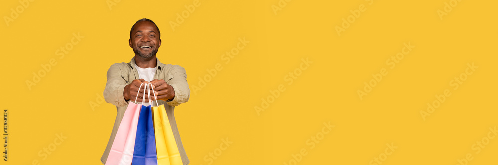Φωτογραφία Cheerful african american middle aged man shopaholic show many packages with purchases from shop, recommend buy, isolated on orange background, studio, copy space