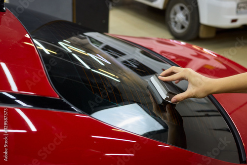 man wearing black gloves applying ceramic coating to car using sponge. Professional car detailing photo