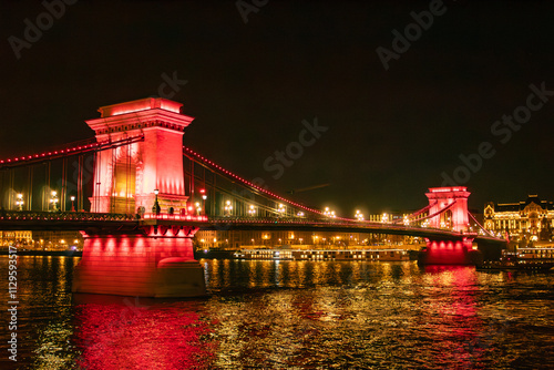 Szechenyi chain bridge with red lighting, at night, in Christmas Budapest