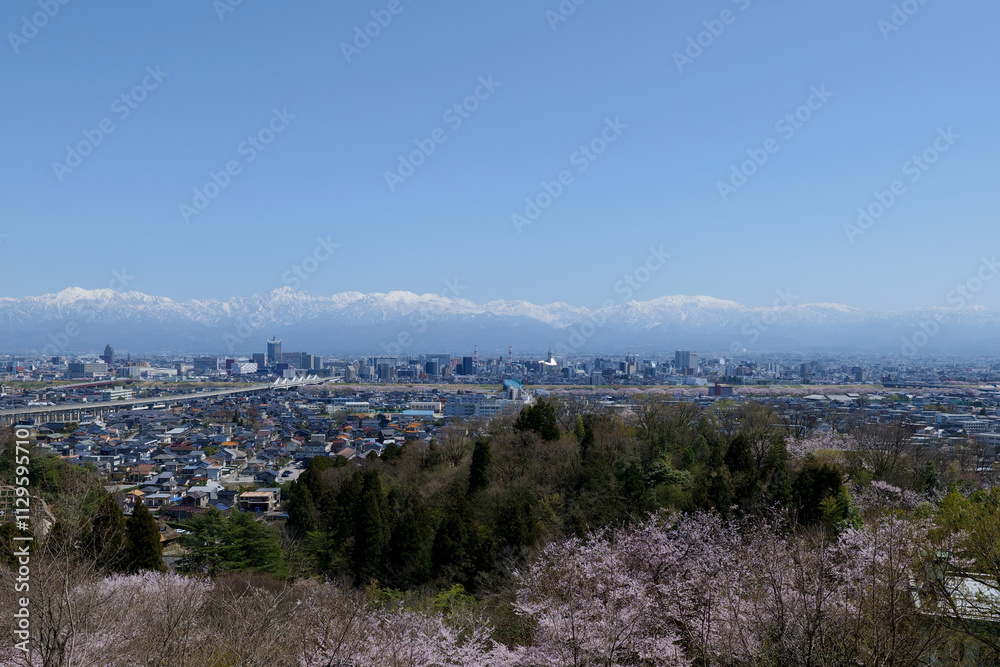 Obraz premium 呉羽山展望台から残雪の北アルプスと富山市街地パノラマ