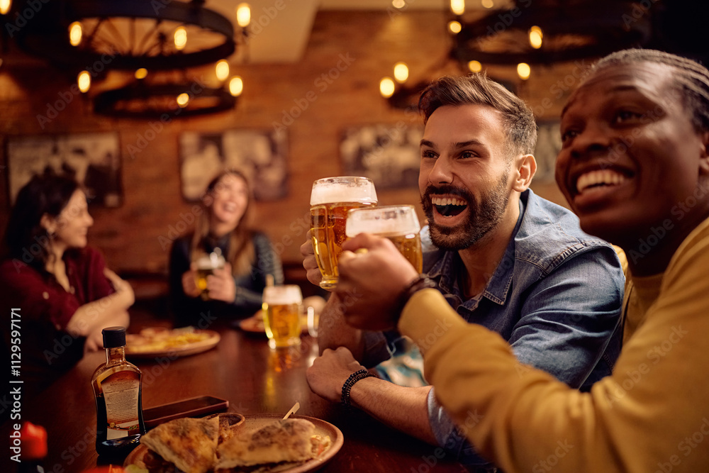 Happy male friends having fun and toasting while drinking beer in pub. Happy male friends having fun and toasting while drinking beer in pub.