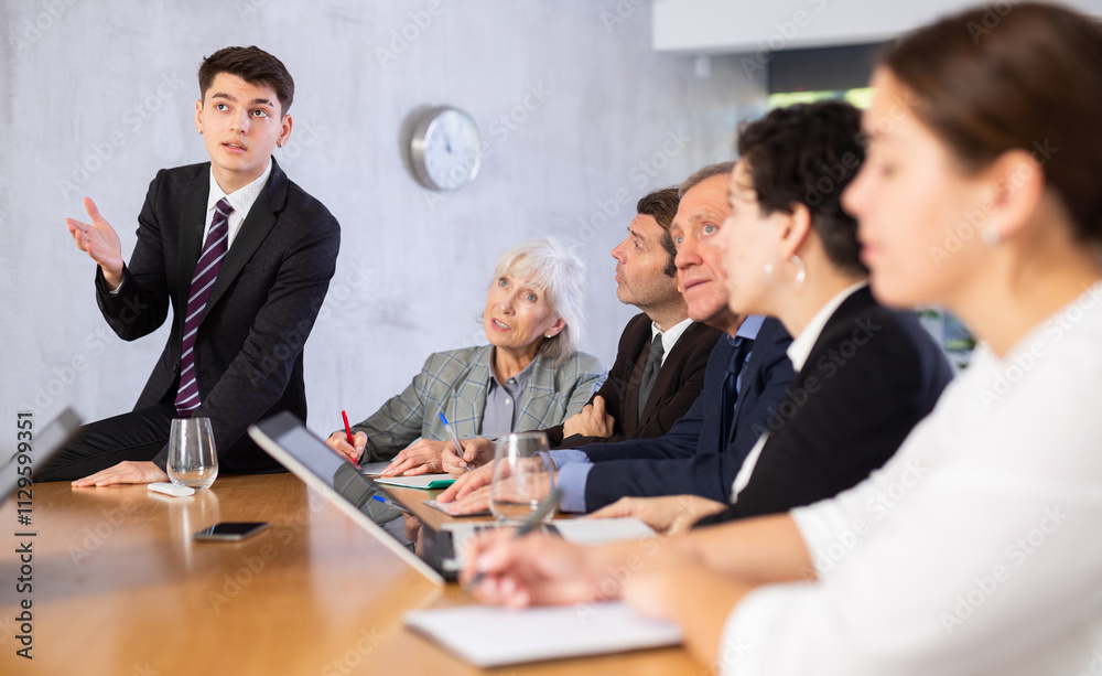 Young successful businessman tells his colleagues the presentation and future plans of the company Young successful businessman tells his colleagues the presentation and future plans of the company