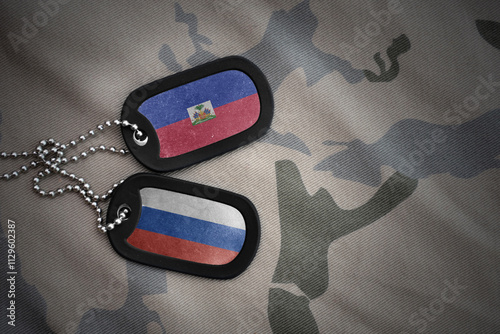 vintage army blank, dog tag with flag of haiti and russia on the khaki texture background. military concept. photo