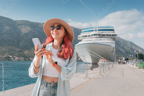 Obraz na płótnie Young woman using smartphone while enjoying vacation near cruise ship in Kotor, Montenegro w salonie