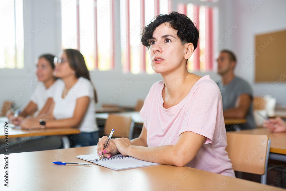 Latin young woman focused on lecture in university. Woman sitting at desk and listening carefully. Latin young woman focused on lecture in university. Woman sitting at desk and listening carefully.