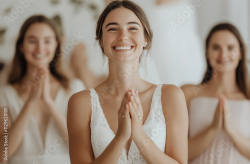 A diverse group of women applauding the bride as she steps out of the fitting room in her dream dress