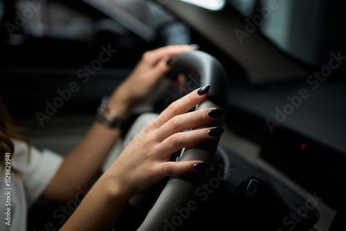 An up close image of a hand precisely adjusting a control in a luxurious automobile interior photo