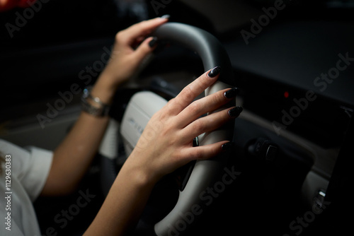 An up close image of a hand precisely adjusting a control in a luxurious automobile interior photo