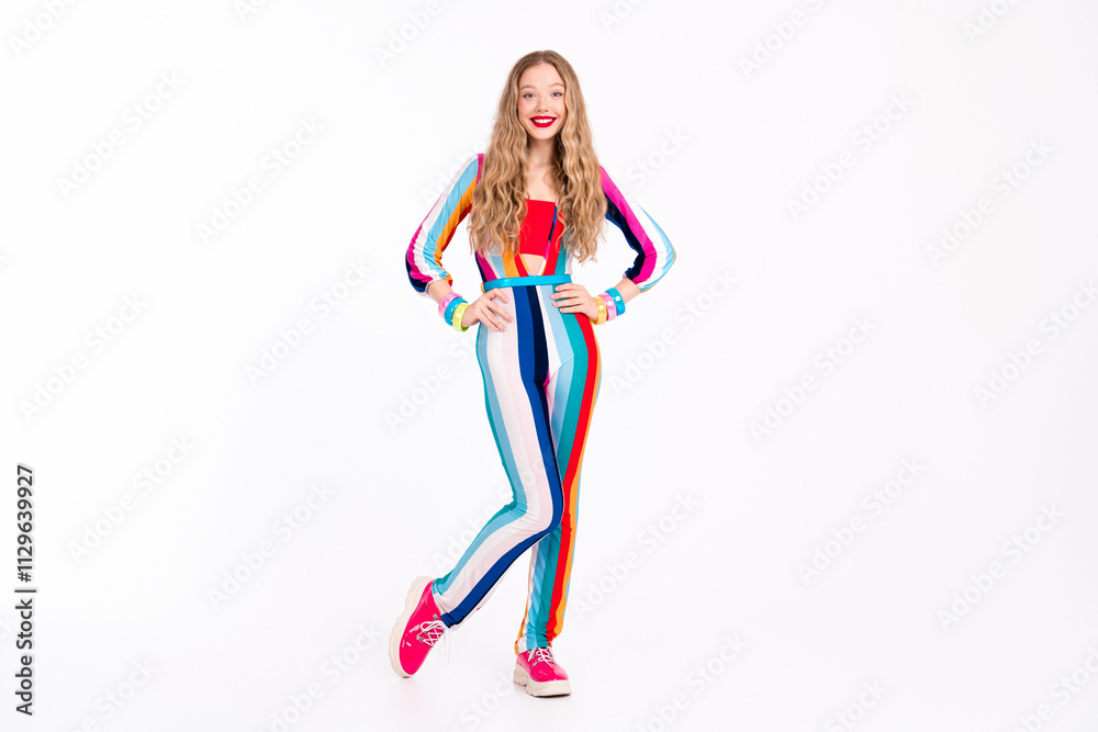 Young woman in vibrant striped outfit poses confidently against a white background, showcasing trendy fashion Young woman in vibrant striped outfit poses confidently against a white background, showcasing trendy fashion