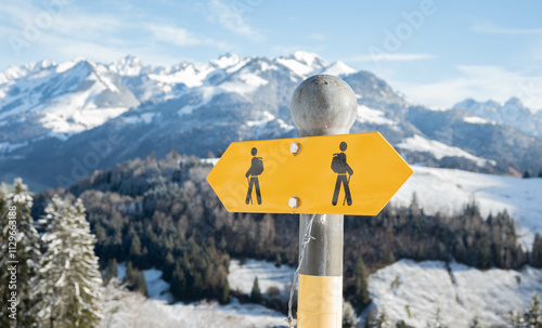 Swiss hiking path sign in the snowy alpine mountains in winter