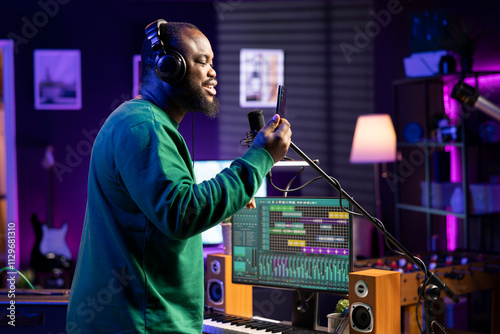 Obraz na plátně Young musician songwriter recording an acoustic version of his song, performing live on microphone in home studio