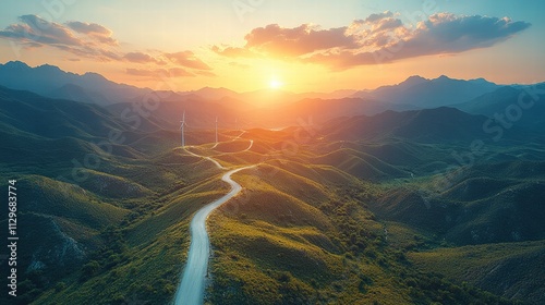 Serene Landscape with Majestic Mountains, Rolling Green Hills, and a Breathtaking Sunset Over a Winding Path and Wind Turbines in the Distance photo