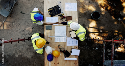 Blueprint, construction site and men at table with handshake, collaboration and agreement from above. Architect, project manager and contractor shaking hands with floor plan, team partnership or deal