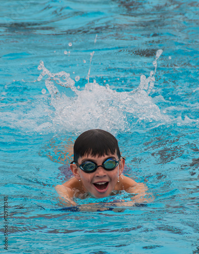 Young boy using a kickboard in an outdoor swimming pool