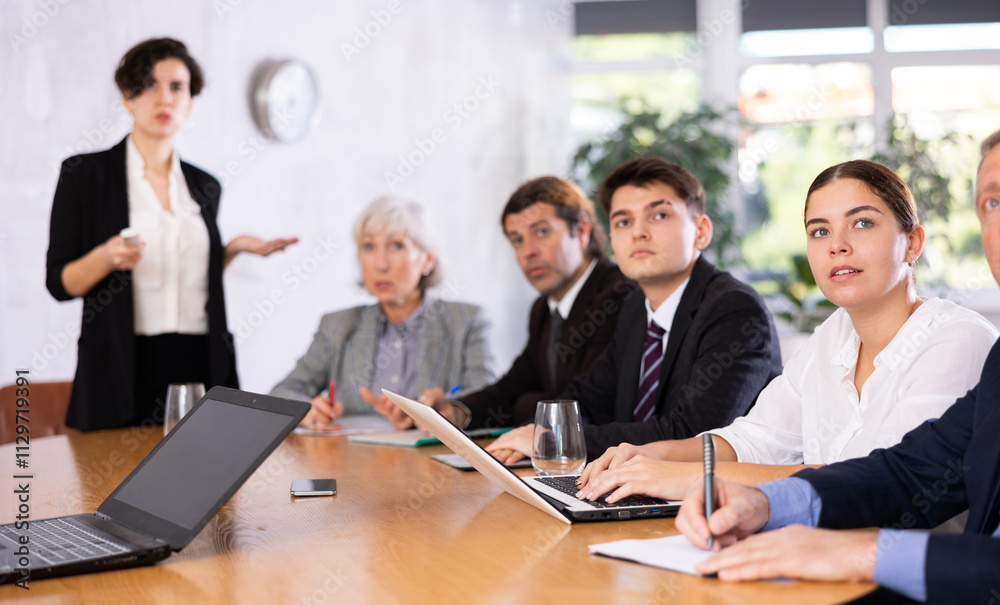 Group of diverse business people attending meeting in conference room, discussing work plan Group of diverse business people attending meeting in conference room, discussing work plan
