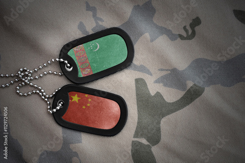 vintage army blank, dog tag with flag of turkmenistan and china on the khaki texture background. military concept.