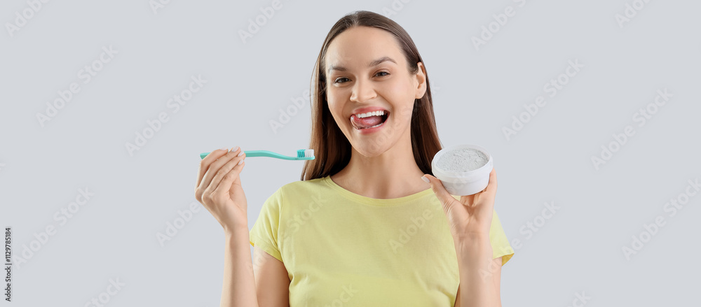 Smiling young woman with tooth powder and brush on light background Smiling young woman with tooth powder and brush on light background
