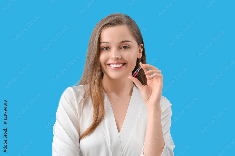 Beautiful young woman with ampule on blue background. Skin care concept Beautiful young woman with ampule on blue background. Skin care concept