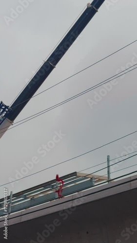 Construction cranes are working on the subway in winter and snow is falling.