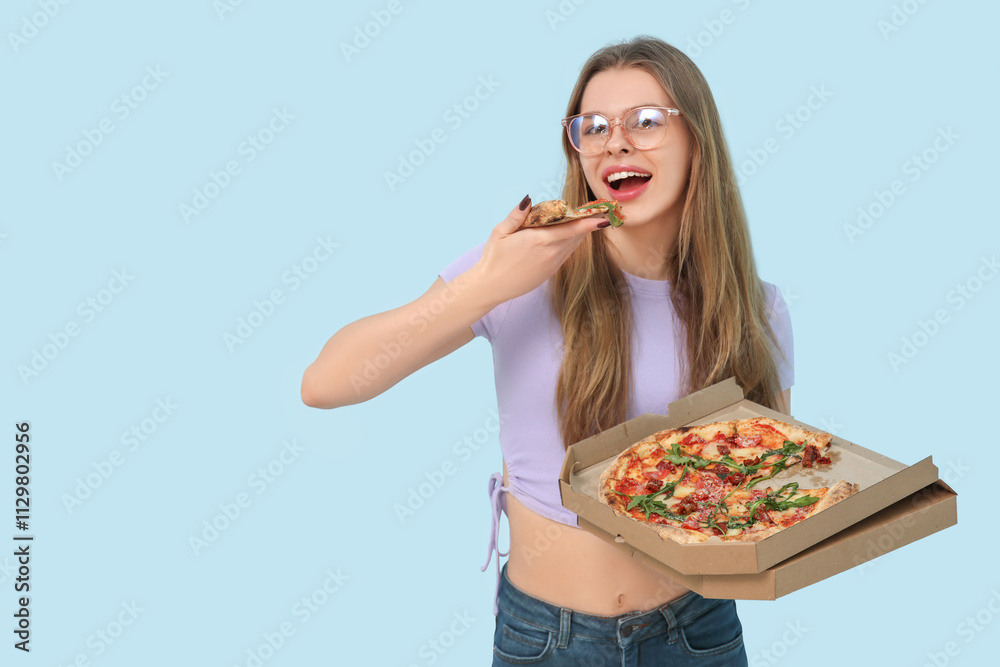 Teenage girl eating delicious pizza Margherita on blue background Teenage girl eating delicious pizza Margherita on blue background
