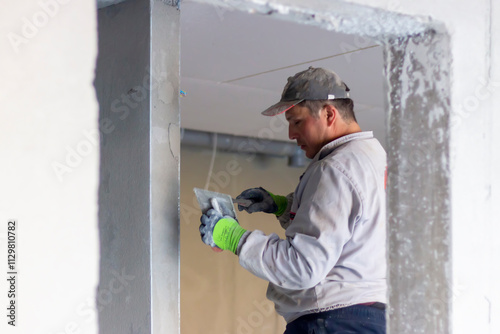 Wallpaper Mural A master plastering a walls. The process of applying plaster on the wall. The concept of renovation and redevelopment of the house Torontodigital.ca