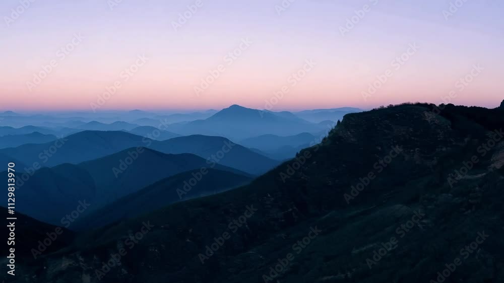 Camera pans across a mountain range, showcasing the vibrant colors of the sky during a stunning sunset Camera pans across a mountain range, showcasing the vibrant colors of the sky during a stunning sunset