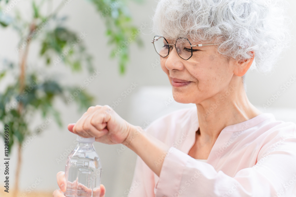 ペットボトルの水を飲むシニア女性