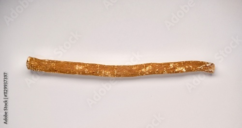 One piece of siwak wood for dental care isolated on horizontal plain background. photo