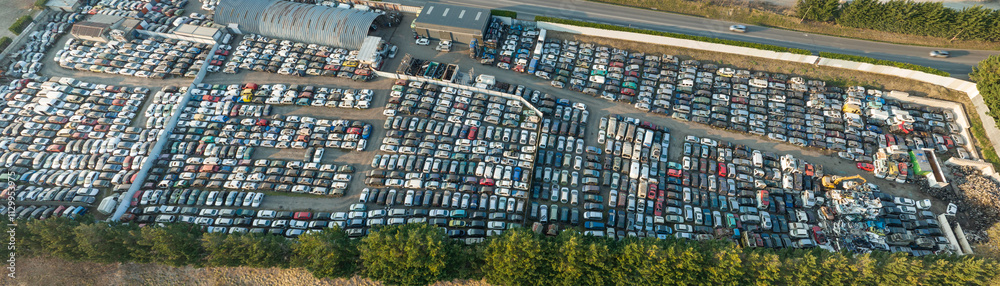 Fototapeta premium Aerial view of big parking lot of junkyard with rows of discarded broken cars. Recycling of old vehicles