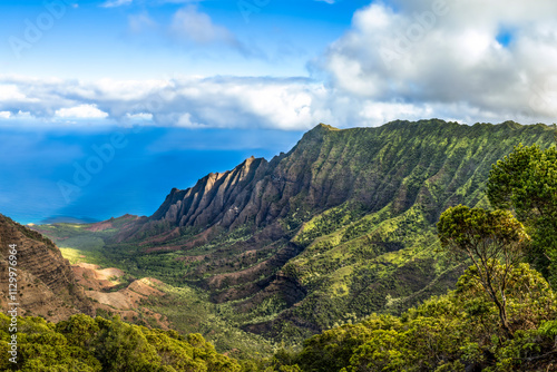 One of the world’s most dramatic landscapes, the Na Pali Coast of Kauai, Hawaii, seen from the Kalalau Lookout, combines deep green valleys, the blue Pacific, and fluctuating weather conditions. photo