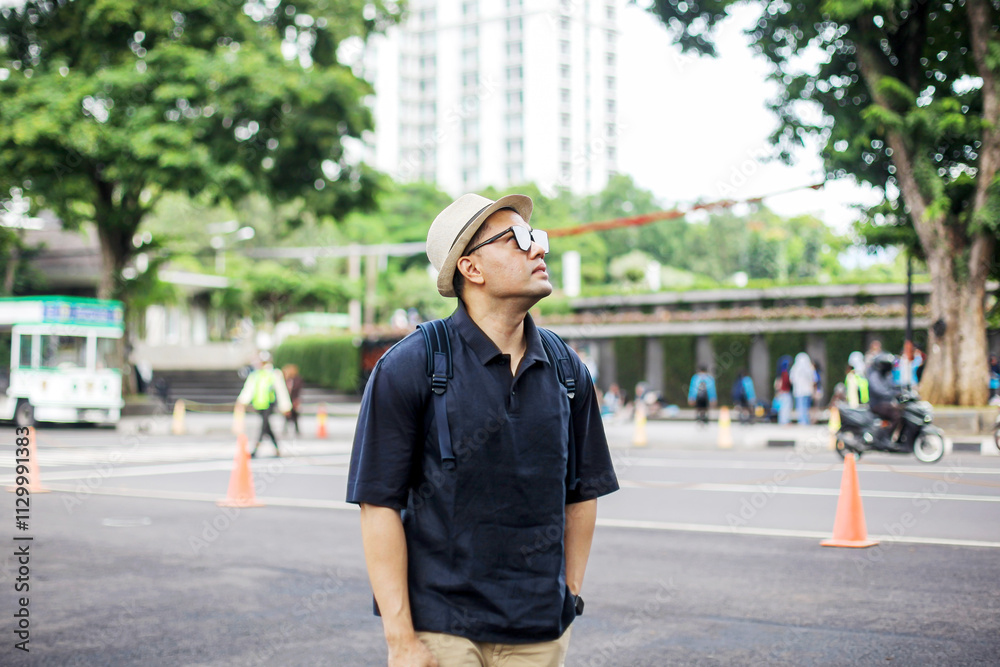 Asian Traveler Man Walking While Looking Away on Sidewalk Asian Traveler Man Walking While Looking Away on Sidewalk