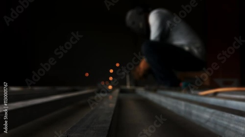 Man welding steel, blurred on black background 