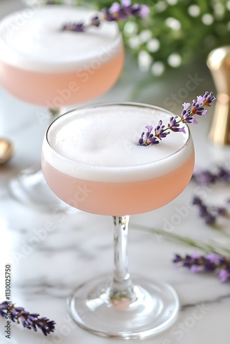 Two Elegant Lavender Cocktails in Coupe Glasses on Marble Surface.