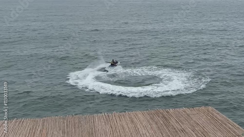 Horizontal video. Top view. Batumi. Georgia. Man rides jet ski and circles sea. Evening sky. Concept of summer vacation, rest, relaxation, relax, calm, yoga, travel, tourism, holiday, transport