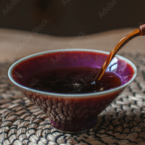 Pouring aromatic tea into a crafted bowl enhances the overall teadrinking experience photo