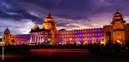 Vidhana Soudha, the Karnataka Legislative house illuminated during dusk with dark clouds in the background photo