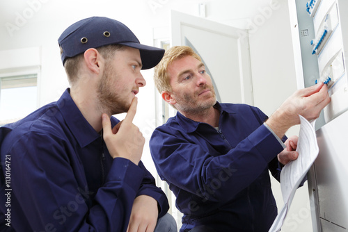 Obraz na płótnie electrical apprentice observing teacher switch the panel