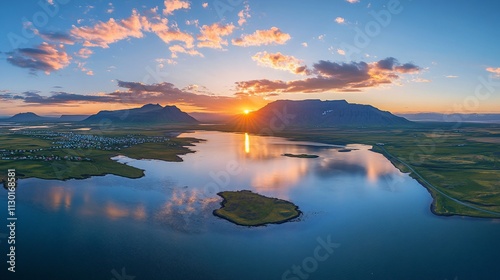 Aerial view of sunset over calm lake and mountains.