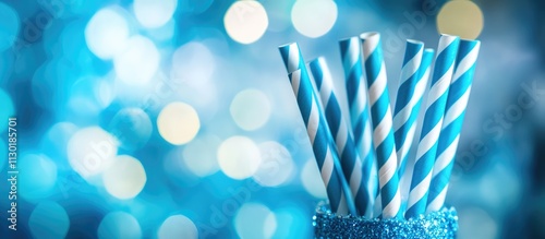 Blue paper straws in a glittery holder celebrating a party against a shimmering blurred background for festive occasions. photo