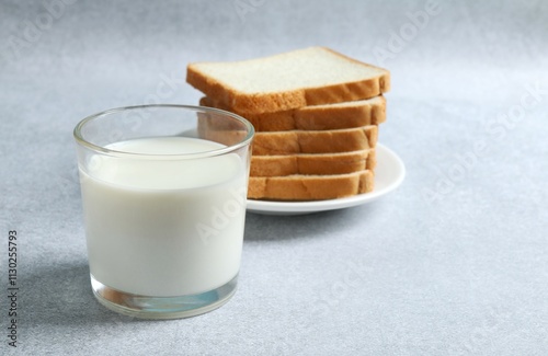 Glass of milk with bread on the table photo