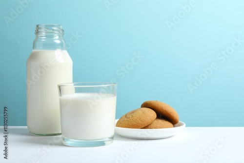 Glass and bottle of milk with cookies on the table photo