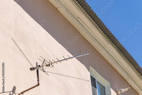 The antenna of the TV signal receiver is mounted on the wall of the house. Terrestrial analog television. Switch to digital broadcasting. Tula region, Russia photo